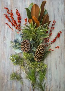 Holiday flower arranging class in long and low style with evergreens, berries, and botanical accents.