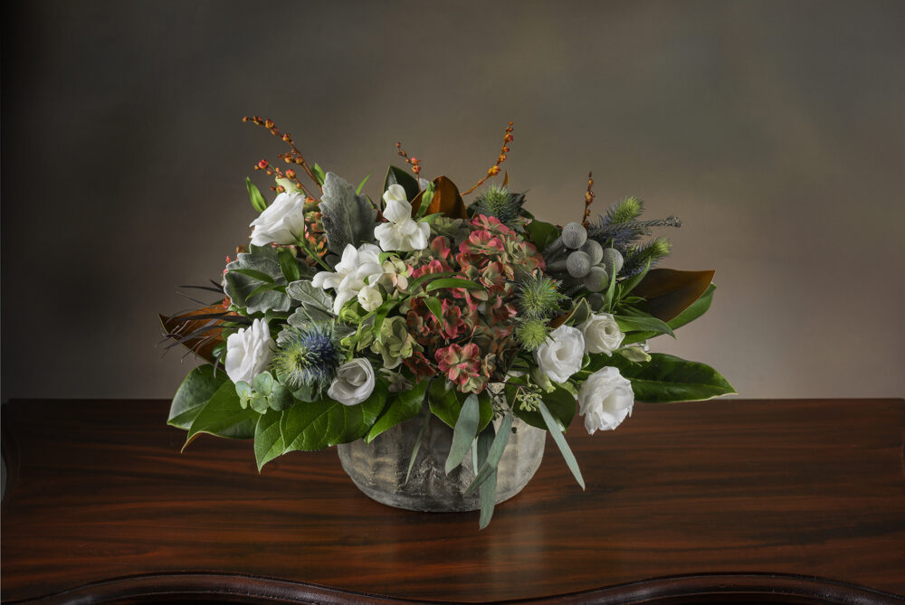 Unique fresh flower arrangement with magnolia foliage, berries and soft flowers delivered