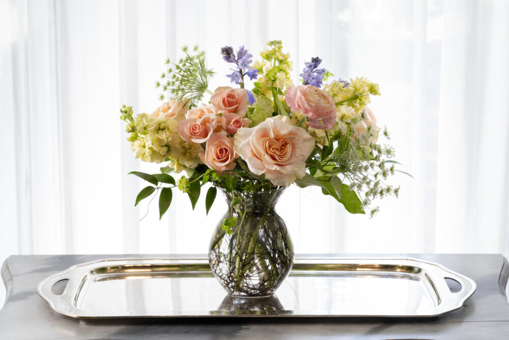 Soft peach, butter yellow, and lavender pastel blooms designed in a bouquet vase for a lovely Mother’s Day gift.