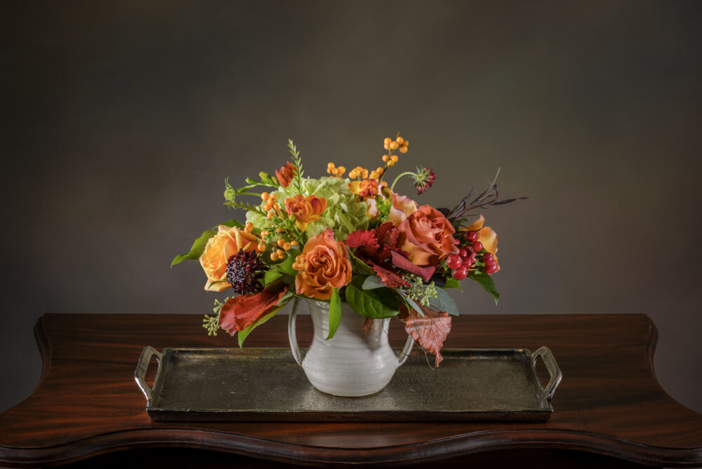 Pretty bright arrangement in coral, orange, and warm purples. Perfect for a greeting or cheerful accent on your table.