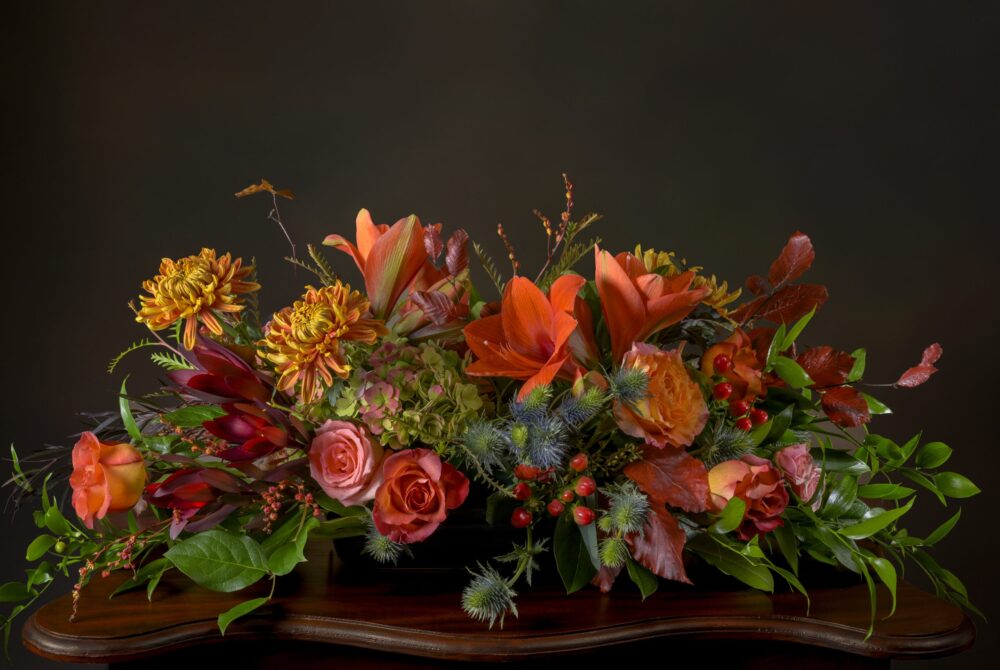 Fresh flowers and foliage Thanksgiving centerpiece, long and low, in rich fall colors.