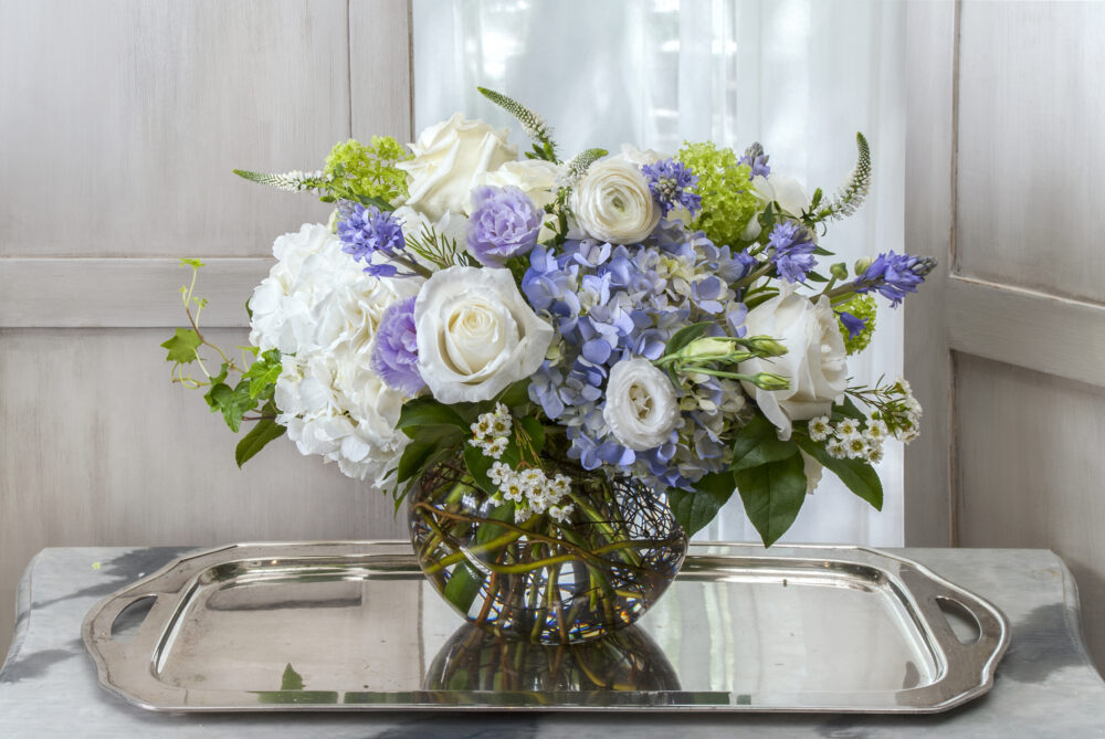 Lovely fresh flower arrangement in white and blue with light touches of lavender designed in a rose bowl, delivered.