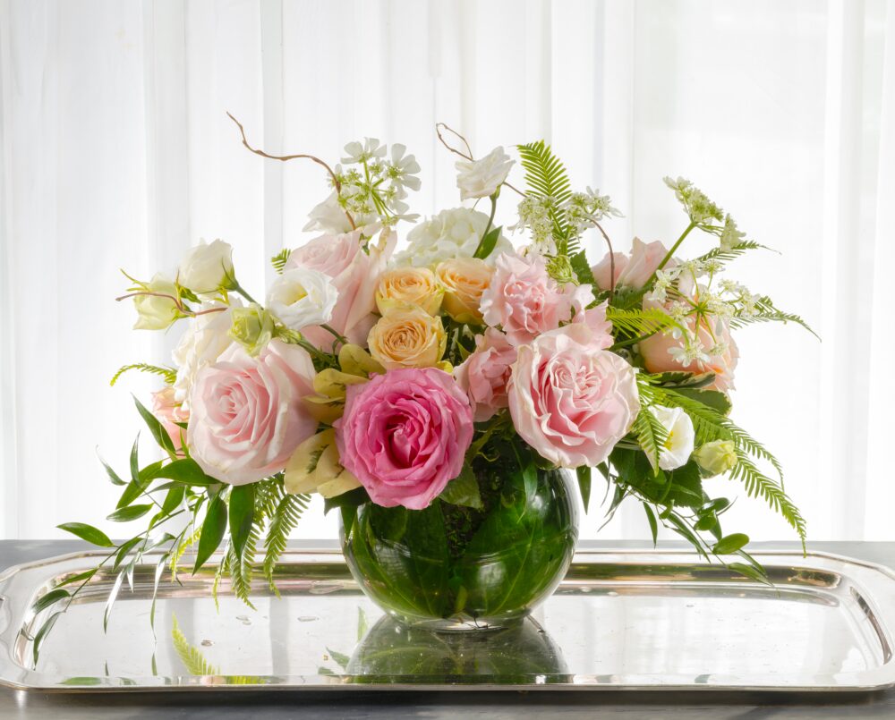 Ashley is a pink pastel arrangement of roses and lisianthus in a round clear glass vase.