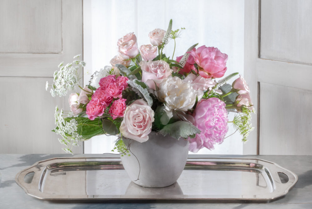 The prettiest pink and white peonies and roses are arranged in a smooth grey pot for a lovely Mother’s Day gift.