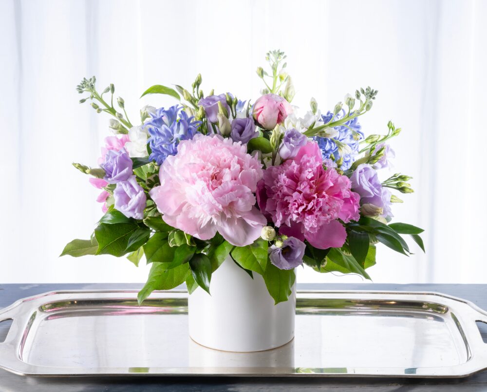 Sonia is a pastel peony arrangement in a white ceramic vase.