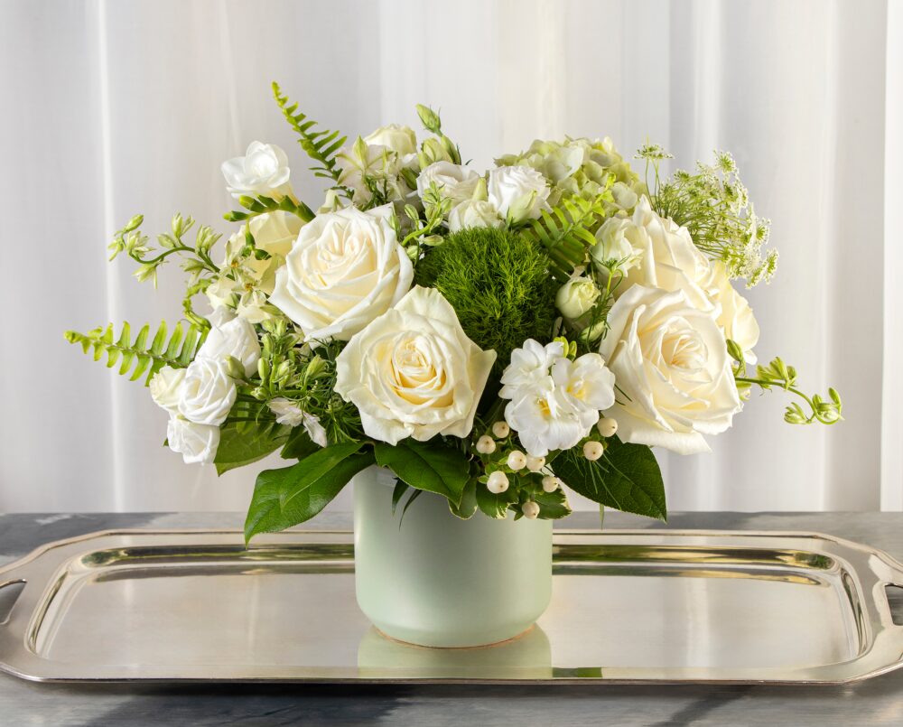 Kirsten is a white and green flower arrangement in a light green ceramic pot.