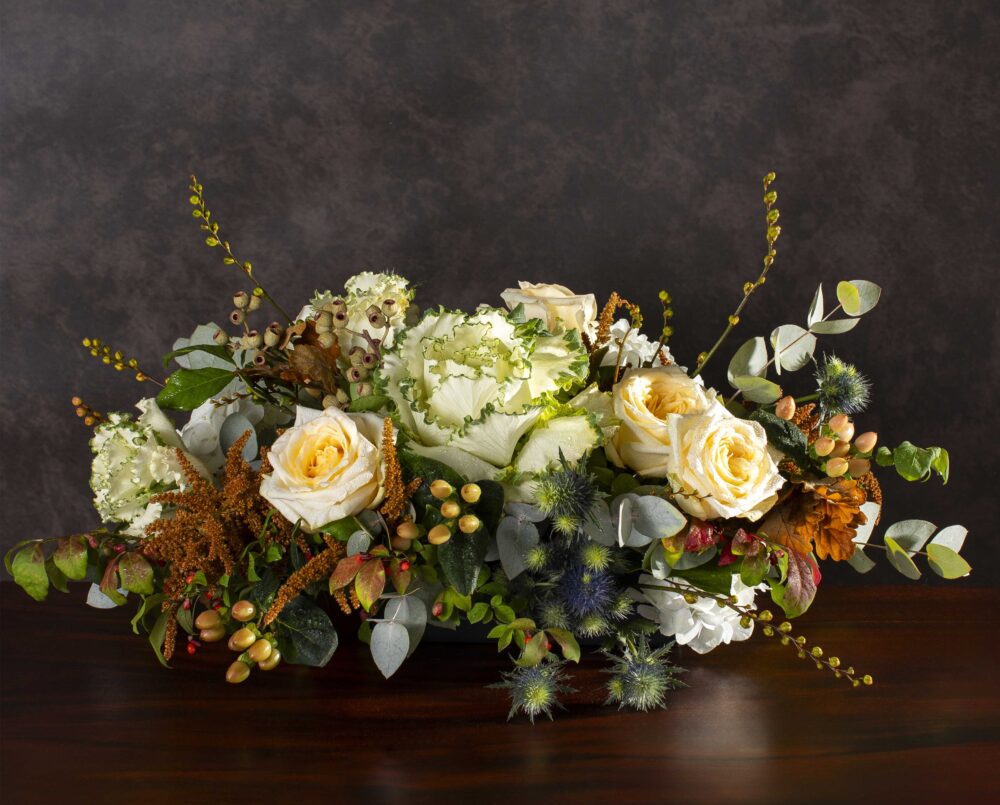 A white, butter yellow, burnt orange, peach and green mix of autumn seasonal flowers in a ceramic vase, delivered, thanksgiving