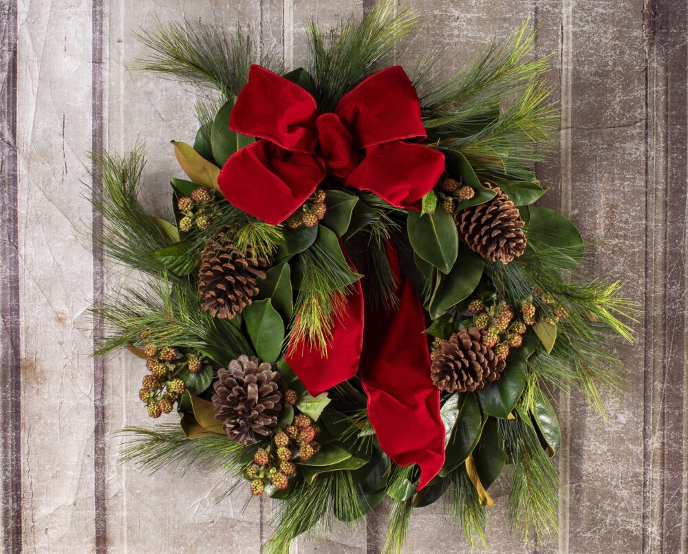 A beautiful, evergreen and magnolia, holiday wreath with velvet red ribbon, delivered.