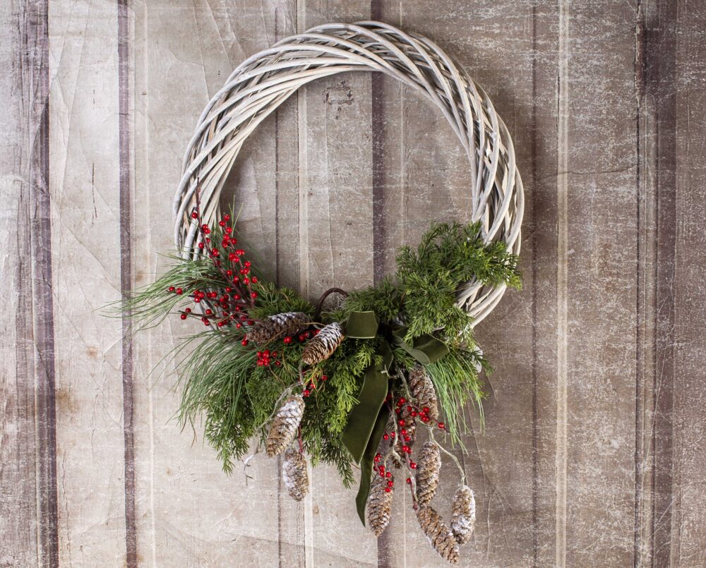 A lovely, simple, white wicker wreath, with cones and red berries, delivered, christmas